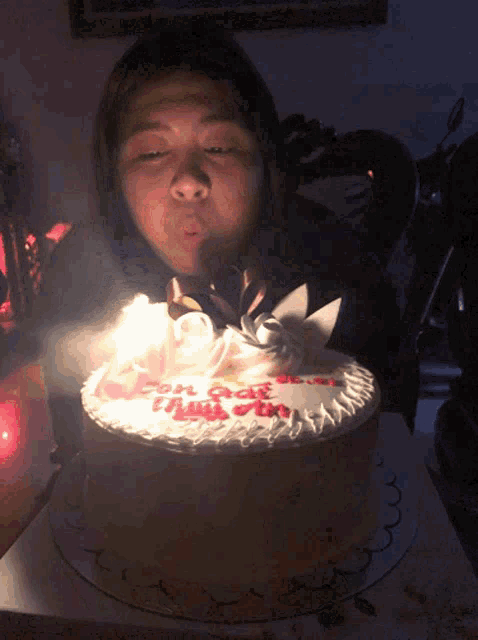 a girl blows out a candle on a cake that says con gao
