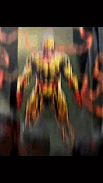 a blurred image of a robot with red arms and legs .