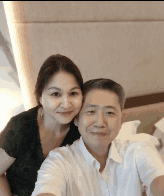 a man and a woman are posing for a selfie