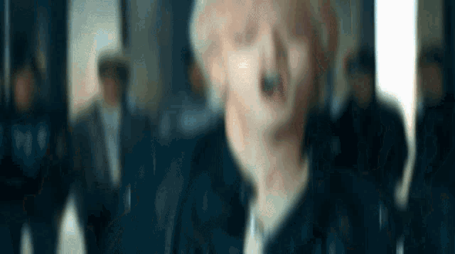 a blurry picture of a man standing in front of a crowd