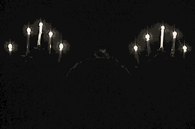 a bunch of candles are lit in the dark