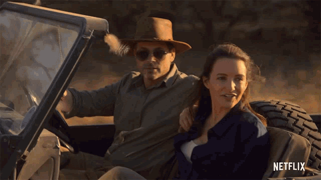 a man and a woman are sitting in a car that says netflix on the bottom right