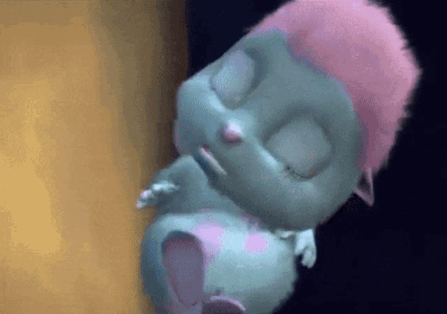 a close up of a cartoon character with pink hair sleeping on a wall .