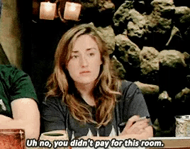 a woman sitting at a table says uh no you didn 't pay for this room