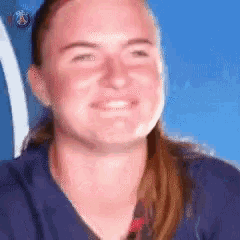 a woman is smiling in front of a blue background