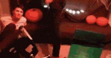 a person is sitting on a couch with a knife in their hand .