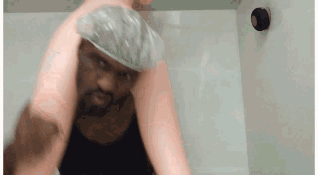 a man wearing a shower cap is being held by a woman