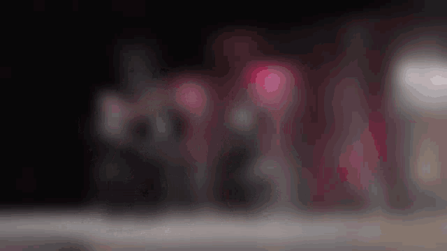 a blurry picture of a group of people in a dark room .