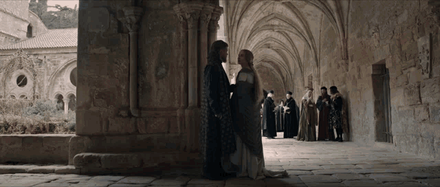 a man and a woman are standing next to each other in a stone building