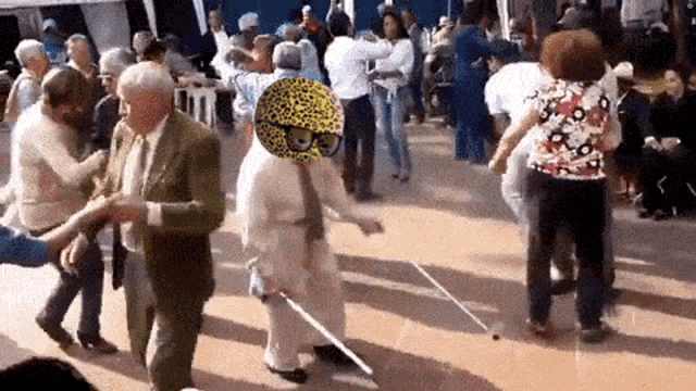 a group of people are dancing on a dance floor and one of them has a leopard hat on