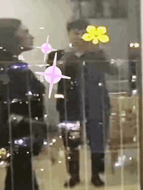 a reflection of a person in a glass window with a yellow flower on it