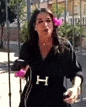 a woman wearing a black shirt with the letter h on the belt