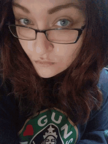 a girl wearing glasses and a shirt that says guns on it