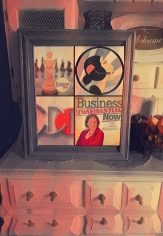 a framed picture of business confidential now on a dresser
