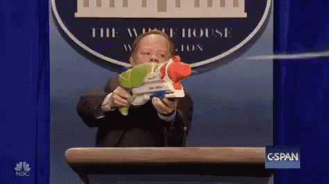 a man is holding a water gun in front of a podium .