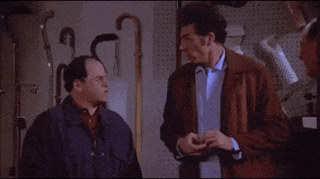 two men are standing next to each other in a garage talking to each other .