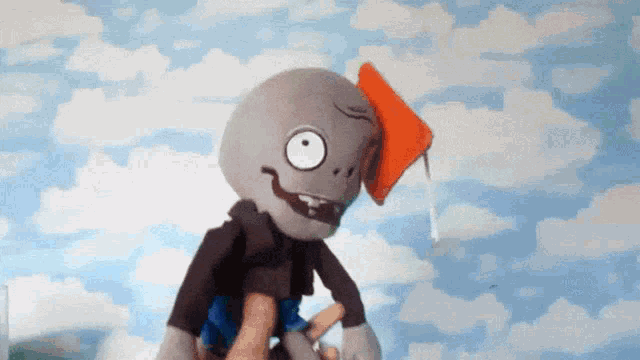 a stuffed cartoon character with a book in his mouth