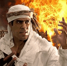 a man wearing a turban is holding a sword in front of a fire .
