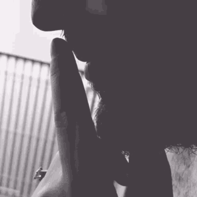 a black and white photo of a man with a beard covering his mouth with his hand