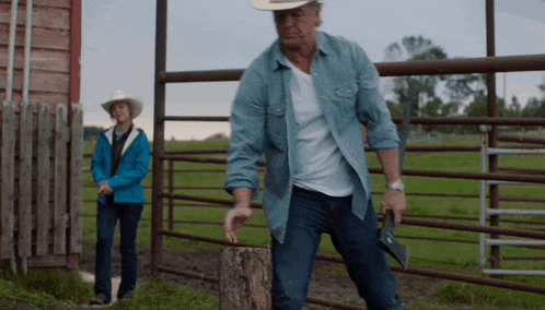 a man in a cowboy hat is standing on a tree stump