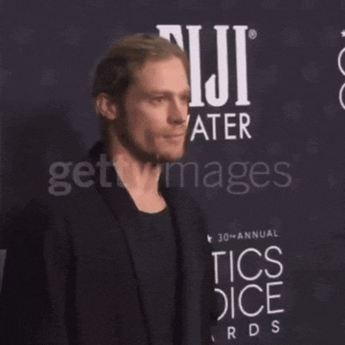a man in front of a fiji water sign