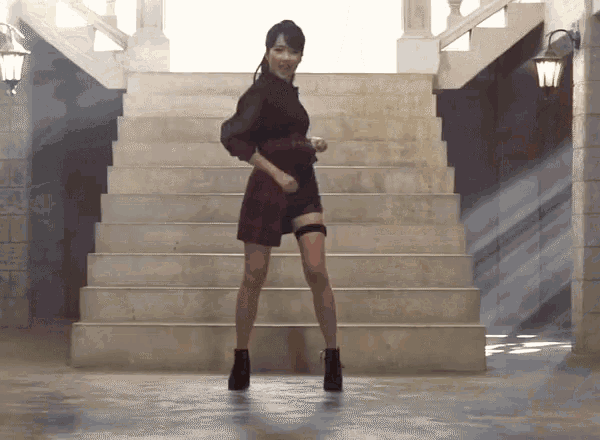 a woman is standing on a set of stairs wearing a black dress