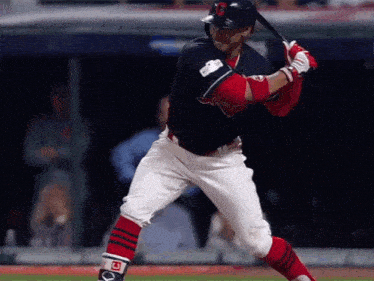 a baseball player with the letter c on his helmet swings at a ball