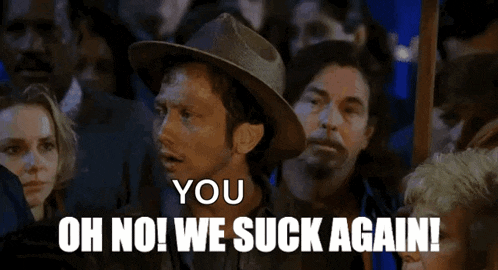 a man in a hat says " you oh no we suck again " in front of a crowd