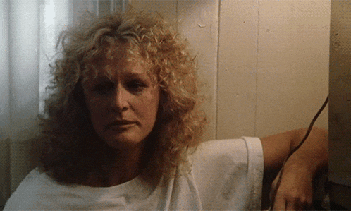 a woman with curly blonde hair and a white shirt