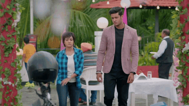 a man in a pink jacket walks with a woman