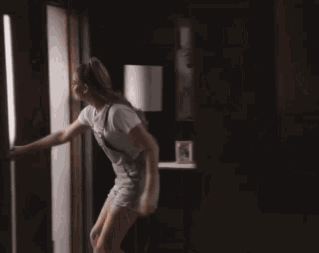 a woman in shorts is standing in a doorway