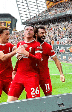 a soccer player with the number 26 on his shorts celebrates with his teammates