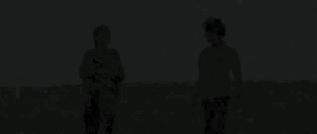 a man and a woman are standing in a field talking to each other