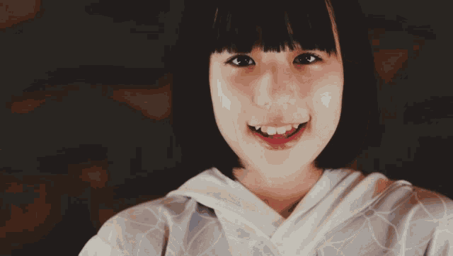a close up of a woman 's face with a white shirt on