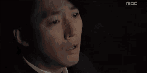 a man in a suit and tie is crying with a tear coming out of his eye .