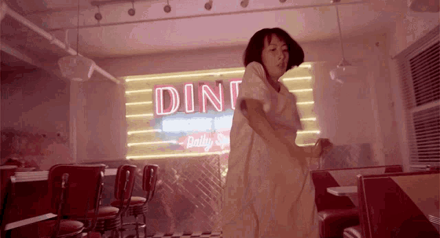 a woman dancing in front of a diner sign that says daily specials