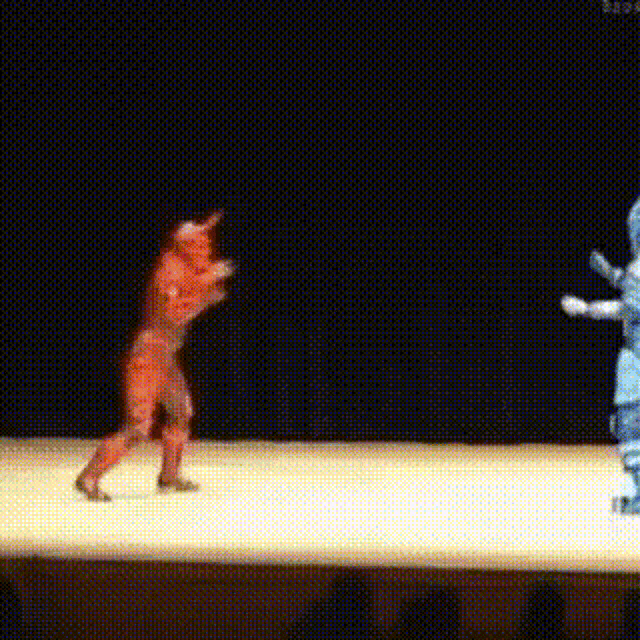 a person in a red suit is dancing on a stage