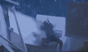 a person is sitting on a toilet in a dark room with smoke coming out of it .