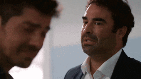 a man in a suit and white shirt is crying while another man looks on
