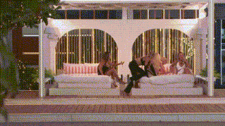 a group of women are sitting on a couch in a room with a gazebo .