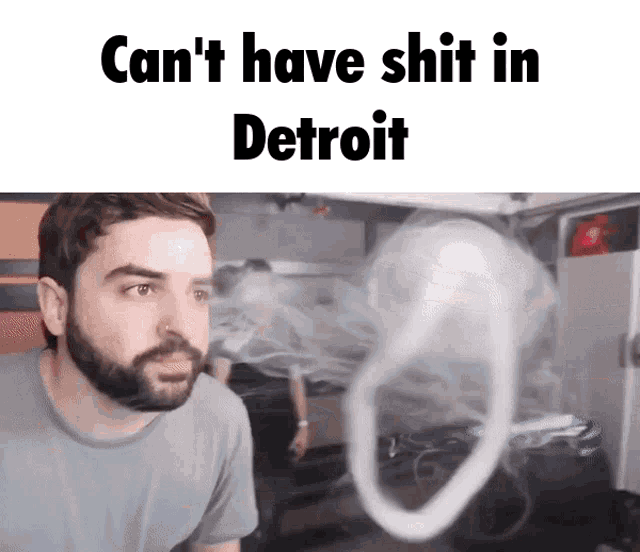 a man with a beard is looking at a smoke ring with the words " can 't have shit in detroit "