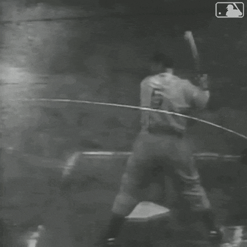 a black and white photo of a baseball player running to base .