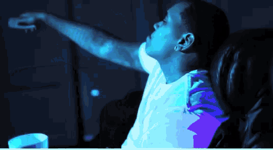 a man is sitting in a chair with his arm outstretched