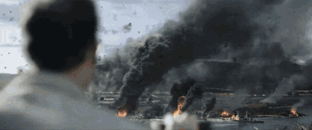 a man is looking at a huge explosion in the ocean