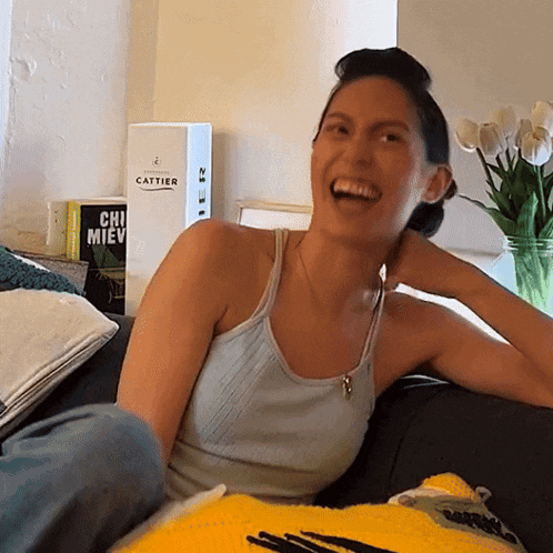 a woman sits on a couch in front of a book titled cattier
