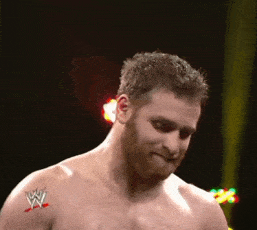 a shirtless wrestler with a tattoo on his arm