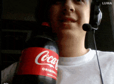 a man wearing headphones holds a bottle of coca cola