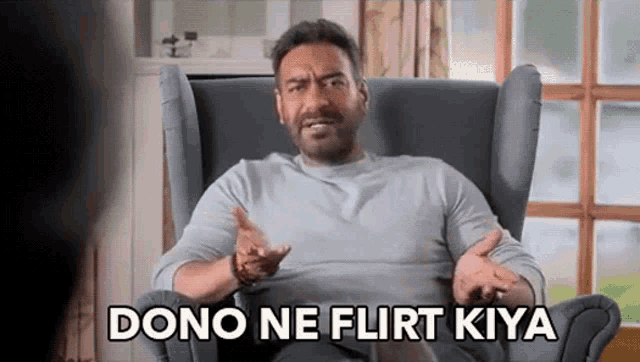 a man is sitting in a chair and making a funny face with the words `` dono ne flirt kiya '' .