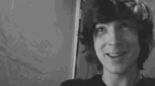 a black and white photo of a young man smiling .