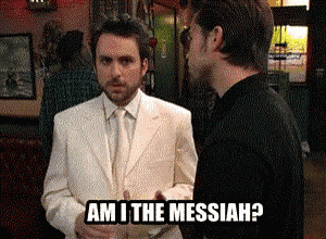 a man in a white suit is asking another man if he is the messiah